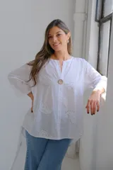 Blusa blanca de mangas largas con cuello mao y cierre frontal con botón de madera.