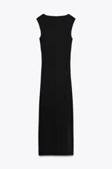 Vestido midi negro de punto, con cuello asimétrico, manga sisa, aplique metálico dorado en el hombro y drapeado lateral.