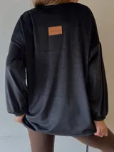 Sobrecamisa negra de plush con mangas abullonadas y cierre frontal con botones.