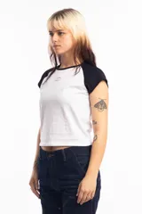 Remera corta gris con mangas ranglan negras y logo ovalado en el pecho.