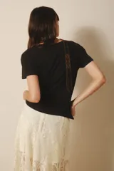 Remera negra de algodón con estampa de un felino dentro de un círculo con rayos de sol.