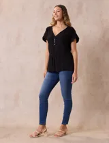 Blusa negra de algodón texturizado marca Zac & Rachel, con escote en V, apliques de botón y lazo de ajuste en la cintura.