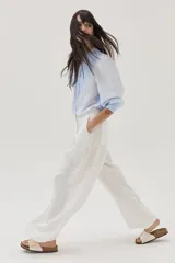 Blusa celeste a rayas verticales blancas, con cuello mao con lazos, mangas abullonadas y corte imperio.