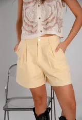 Short amarillo de gabardina, tiro alto y corte holgado.