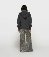 Pantalón deportivo ancho de corte regular con estampado de leopardo, confeccionado en suave algodón orgánico con certificación GOTS. Cuenta con cintura elástica con trabillas para cinturón, bolsillos laterales inclinados y el número '10' bordado debajo del bolsillo izquierdo.