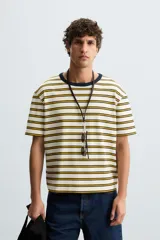 Camiseta de hombre de corte relajado, color crudo con rayas horizontales color ocre y cuello redondo azul marino en contraste.
