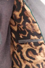Blazer de lana fría con forro de animal print, hombreras y botones frontales.