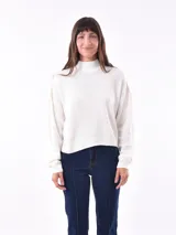 Sweater beige de cuello alto y mangas largas.