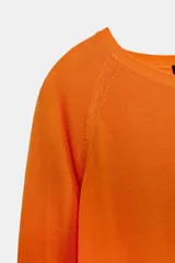 Jersey de punto liso, color azul brillante, con cuello redondo y manga larga. Presenta acabados en rib en puños, cuello y bajo, con aberturas laterales en el ruedo.