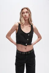 Chaleco crop top de jean celeste con botones frontales.