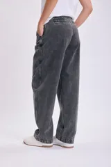 Pantalón de jean negro de corte carrot, tiro alto y pierna ancha.