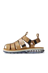 Sandalias con tiras de tela color beige, suela gruesa con detalles geométricos y ajuste con velcro.