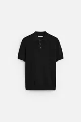 Polo negro de punto con cuello solapa, manga corta y cierre frontal con tres botones.