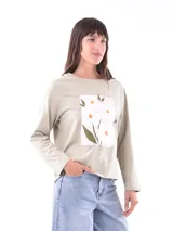 Remera color verde claro con estampado de flores blancas y hojas verdes en el frente.
