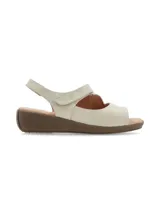 Sandalias de cuero color crema, con plataforma marrón y ajuste de velcro.