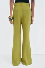Pantalón de vestir color verde oliva, de tiro medio, corte flare y bolsillos laterales.