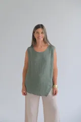 Musculosa verde oliva de lino italiano, de corte recto, con escote redondo y ruedo asimétrico.