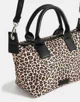 Cartera mini city color negro con doble asa corta de mano, correa regulable ajustable, cierre superior y tag de goma.