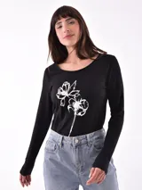 Remera verde militar de manga larga con cuello en V y estampado floral en tonos naranja.