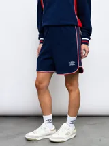 Short deportivo azul marino con ribetes blancos y rojos, y escudo del Club Nacional de Football bordado en la pierna derecha.