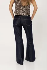 Pantalón de jean azul oscuro de corte bootcut, con cintura media entallada y proceso de suavizado.
