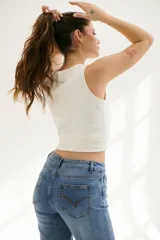 Pantalón de jean azul de corte acampanado, con bolsillos delanteros y traseros, y detalle de cuero sintético en la cintura.