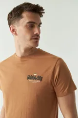 Remera color caramelo de manga corta con cuello redondo y estampado en el frente con la leyenda "Golden City Brookshield".