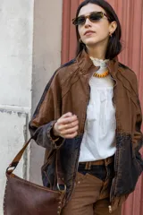 Campera bomber marrón con mangas y parte inferior en denim negro desgastado.