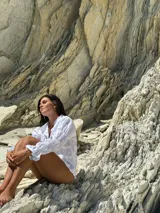 Camisa color beige de lino, de corte recto y cuello clásico. Tiene mangas largas abullonadas con frunces y puños elásticos.