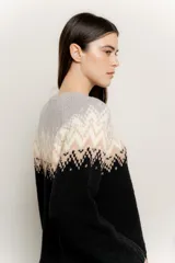 Sweater de punto con cuello redondo, mangas largas y diseño de guardas geométricas en tonos gris, beige y blanco en la parte superior, y negro en la parte inferior.