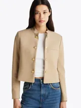 Americana beige de corte slim con cuello mao, cierre de gancho oculto, bolsillo de ojal en el pecho, totalmente forrada y logo esmaltado de Tommy Hilfiger en el puño.