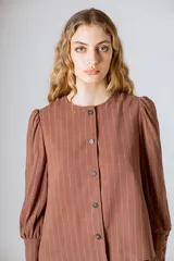 Chaqueta negra de lino con mangas abullonadas y cierre frontal con botones.