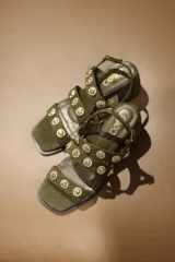 Sandalias de tiras color verde militar con apliques de tachas doradas.