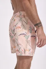 Short de baño color rosa con estampado de hojas y flores en tonos verdes, marrones y blancos.