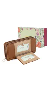 Billetera larga color plateado metalizado, con cierre perimetral y placa con el logo "Lincoln's" al frente. Presenta múltiples compartimentos y tarjeteros.