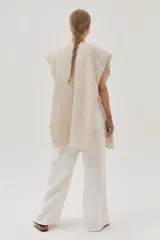 Ruana beige de tejido de punto acanalado con mangas cortas.