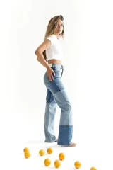 Pantalón de jean con diseño patchwork en diferentes tonos de azul, corte recto y tiro alto.