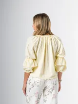 Blusa color amarillo pálido de algodón, con cuello mao y mangas 3/4 abullonadas con volados.