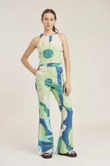 Pantalón de corte flared con estampado colorido y detalles florales.