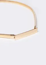 Cinto elastizado dorado con placa rectangular metálica.