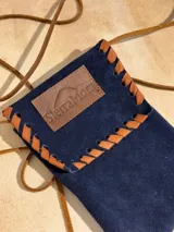 Funda para celular de gamuza azul marino con correa de cuero marrón y aplique de cuero marrón con logo de la marca.