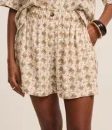 Short femenino modelo runner confeccionado en viscolino con cintura elástica, botón delantero, bolsillos y estampa de palmeras.