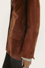 Blazer de cuero color marrón, con cuello solapa de muescas y manga larga. Tiene bolsillos con solapa en delantero, forro interior y cierre frontal con botones.