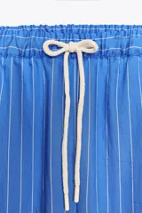 Pantalón de lyocell con rayas verticales blancas y azules, tiro medio, cintura elástica ajustable con cordones, bolsillos delanteros y pierna recta.