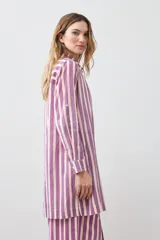 Vestido camisero a rayas verticales fucsia y blanco, con cuello camisero, mangas 3/4 con puños abotonados y cierre frontal con botones.