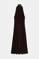 Vestido largo color marrón oscuro, con cuello alto y corte al cuerpo en la parte superior, y falda acampanada con pliegues. Presenta tirantes finos que dejan los hombros al descubierto.