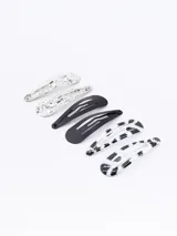 Pack de seis hebillas para el pelo tipo sapitos, con diseños variados: dos plateadas con textura, dos negras lisas y dos con estampado animal print en blanco y negro.