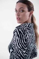 Vestido midi con estampado cebra, corte al cuerpo, cuello camisero y abotonadura frontal.