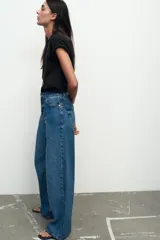Jeans de tiro medio, color azul denim, con cinco bolsillos, corte wide leg y largo extra.