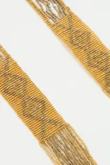 Collar tipo gargantilla de cuentas doradas y negras con diseño geométrico.